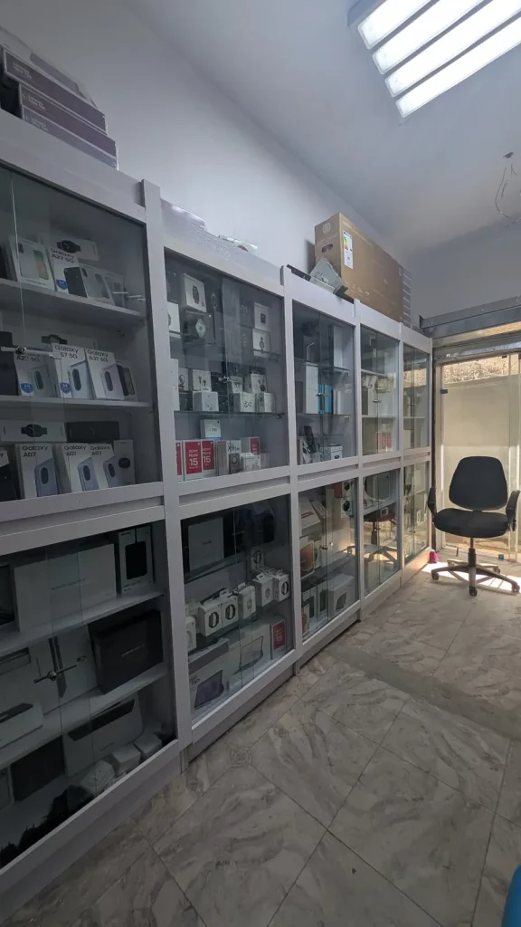 Inside Shop G17: glass shelves of boxed phones, smartwatches and tablets